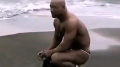 Asian bodybuilder barely covered at the beach